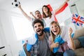 Soccer fans emotionally watching game in the living room. Royalty Free Stock Photo