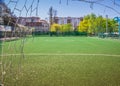 Soccer field with artificial green grass near the school. Amateur football field. Sunny summer day Royalty Free Stock Photo