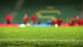 Soccer field grass with rain drops with unfocused team training process on the background