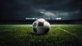 A soccer field with green grass, soccer ball lying on the field, rain coming down