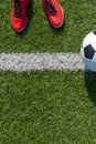 Soccer football background. Soccer ball and pair of football sports shoes on artificial turf soccer field. Top view Royalty Free Stock Photo