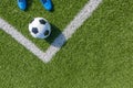 Soccer football background. Soccer ball and pair of football sports shoes on artificial turf soccer field with white Royalty Free Stock Photo