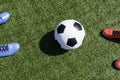 Soccer football background. Soccer ball and two pair of football sports shoes on artificial turf soccer field with Royalty Free Stock Photo