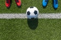 Soccer football background. Soccer ball and two pair of football sports shoes on artificial turf soccer field Royalty Free Stock Photo