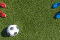 Soccer football background. Soccer ball and two pair of football sports shoes on artificial turf soccer field Royalty Free Stock Photo