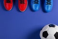 Soccer football background. Top view of soccer ball and two pair of soccer football sports shoes on blue background Royalty Free Stock Photo