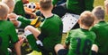 Soccer football coach having tactic strategy speech with kids team. Kids listening coachs strategy speech. School team coach using