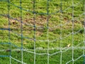 Soccer or football corner lines through safety net. View from behind the tribune net with blurred stadium and field pitch Royalty Free Stock Photo