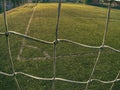 Soccer or football corner through net. View from behind the tribune net with blurred stadium and field pitch Royalty Free Stock Photo