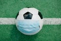 Soccer football with face mask for sports during covid-19 pandemic Royalty Free Stock Photo
