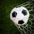 Soccer football in Goal net with green grass field. Royalty Free Stock Photo