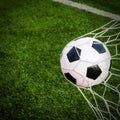 Soccer football in Goal net with green grass field. Royalty Free Stock Photo