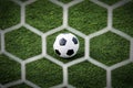 Soccer football in Goal net with green grass field. Royalty Free Stock Photo