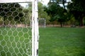 Soccer football net background over green grass and blurry stadium. Background of soccer football goal in stadium on match day