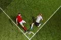 Soccer football players wearing sportswear, uniform hitting the ball over green grass field background. Dynamic shot Royalty Free Stock Photo