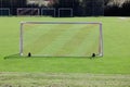 soccer goal photographed from behind on a green spring meadow without goalkeeper and players. in the background other substitute Royalty Free Stock Photo