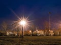 Soccer goal post illuminated by flood light at night. Football pitch at dusk. Light flare. Nobody. Sport background