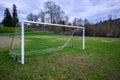 Soccer goal on a wet and worn grass field, stormy sky in the background Royalty Free Stock Photo