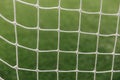 Soccer net background, view from behind the goal with blurred field pitch. Football match Royalty Free Stock Photo