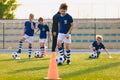 Soccer physical education lesson. Children training football on schools field