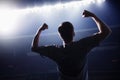 Soccer player with arms raised cheering, stadium at night time Royalty Free Stock Photo