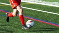Soccer player dribbling ball on green turf field Royalty Free Stock Photo