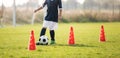 Soccer player dribbling through cones in the ground on a sunny Royalty Free Stock Photo