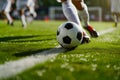 A soccer player dribbling and kicking a ball on a field Royalty Free Stock Photo