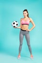 Soccer player. Full length of young beautiful woman in sportswear holding soccer ball and smiling at camera while Royalty Free Stock Photo