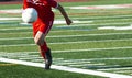 Soccer player in red uniform chasing the ball Royalty Free Stock Photo