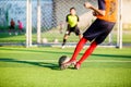 Soccer player run to shoot ball at penalty kick to goal with blurry goalkeeper background Royalty Free Stock Photo