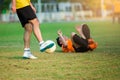 Soccer player shoot ball to goal with blurry other player fell and was injured on green grass Royalty Free Stock Photo