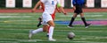 Soccer player in white uniform controlling the ball dribbling across the field during a game Royalty Free Stock Photo