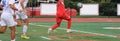 Soccer players chasing a bouncing soccer ball