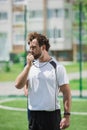 Soccer referee whistling in whistle on soccer pitch during game Royalty Free Stock Photo