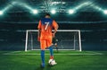 Soccer scene at night match with player in orange uniform kicking the penalty kick Royalty Free Stock Photo