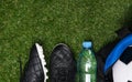 Soccer shoes, water bottle and ball in a sports bag on a green lawn Royalty Free Stock Photo