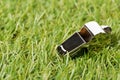 Soccer sports chrome whistle on grass background - penalty, foul or sports concept