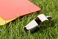 Soccer sports referee yellow and red cards with chrome whistle on grass background selective focus Royalty Free Stock Photo