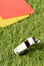 Soccer sports referee yellow and red cards with chrome whistle on grass background selective focus Royalty Free Stock Photo