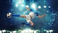 Soccer striker hits the ball with an acrobatic kick in the air on dark blue background Royalty Free Stock Photo