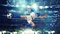 Soccer striker hits the ball with an acrobatic kick in the air at the stadium Royalty Free Stock Photo