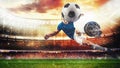 Soccer striker hits the ball with an acrobatic kick in the air at the stadium at sunset Royalty Free Stock Photo