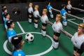 Soccer table game. Green field with blue and white plastic footballers Royalty Free Stock Photo