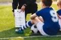 Soccer Team Meeting. Coach Giving Tactic Advices Using Football White Board