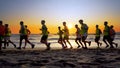 Soccer team training and running outdoor under the beach sunset