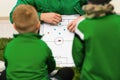 Soccer trainer coach explaining tactics to kids football team