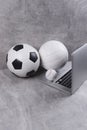 Soccer, volleyball and baseball ball and grey laptop on grey background. Online workout concept. Green color filter