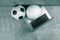 Soccer, volleyball and baseball ball and grey laptop on grey background. Online workout concept. Green color filter