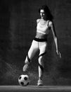 Soccer woman player jumps and hit the ball strike in the middle on concrete loft wall Royalty Free Stock Photo